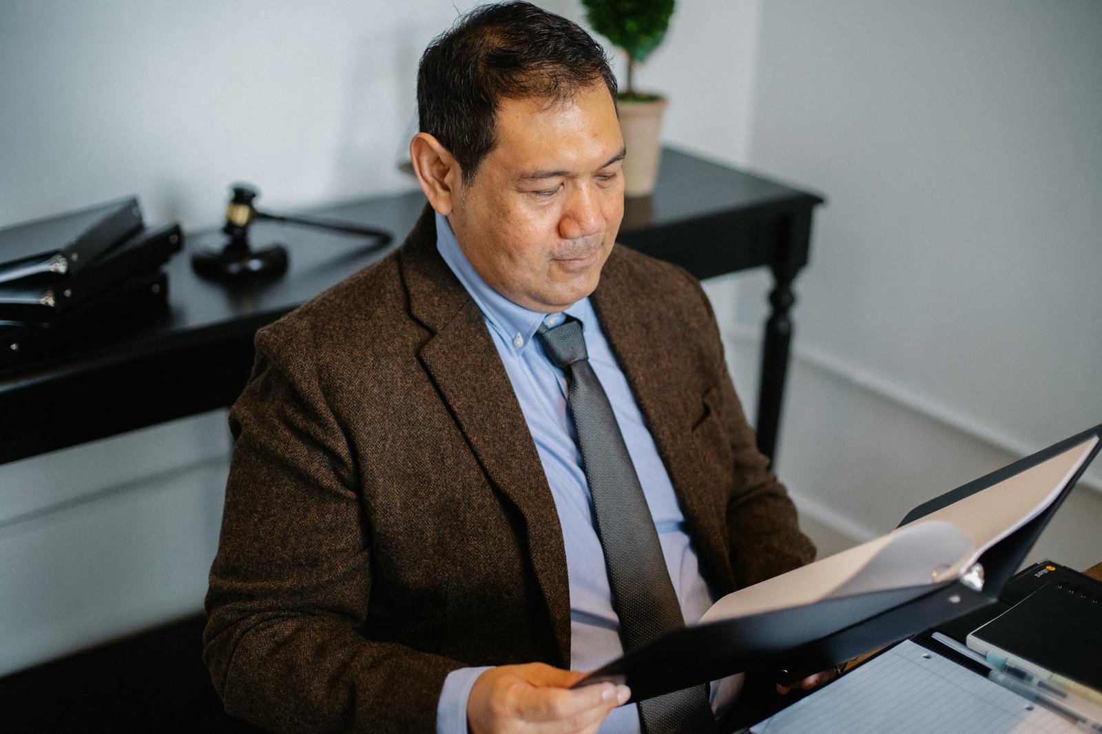 electrician reviewing electrical documents on a desk with blueprint background