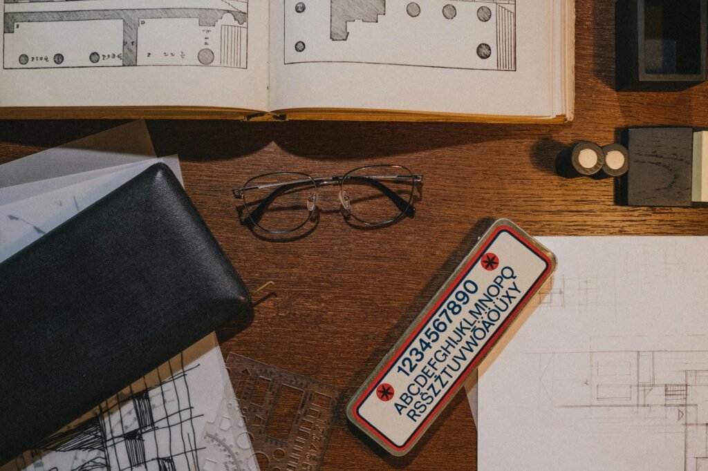 electrician certification documents on desk with blueprints and meter reading tools