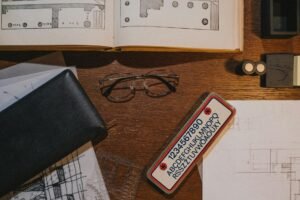 electrician certification documents on desk with blueprints and meter reading tools