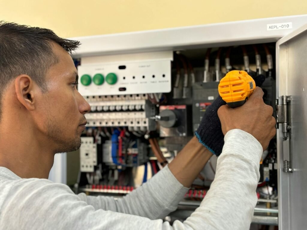electrician reviewing certification documents on desk with electrical panel background