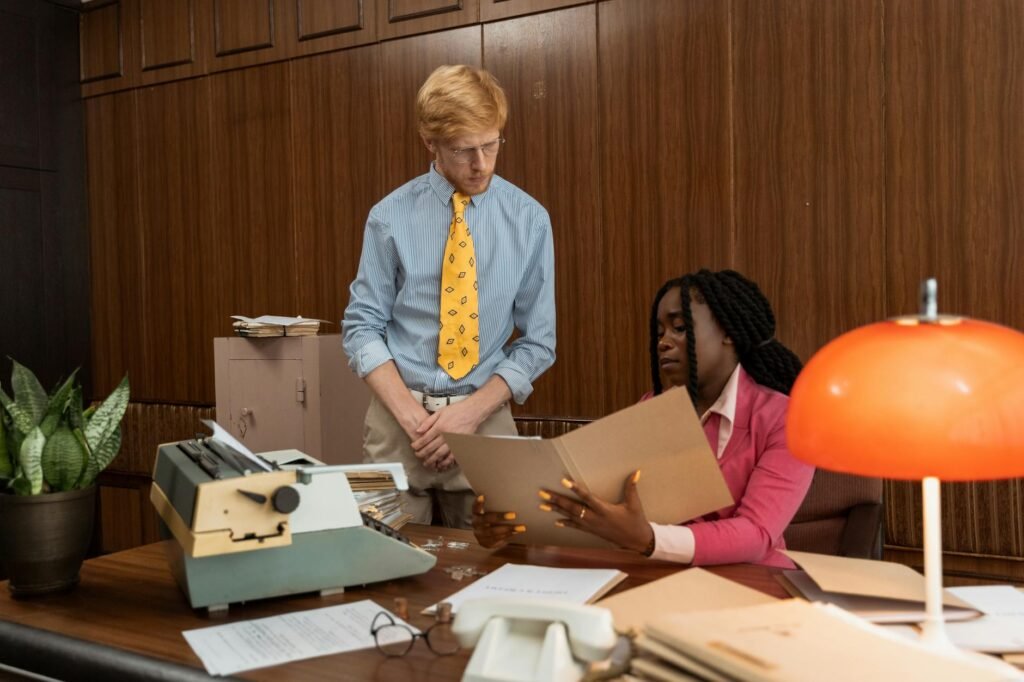 electrician reviewing electrical certification documents and panel on a desk