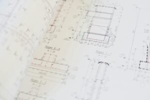 electricity certification documents and meter on desk with blueprint background